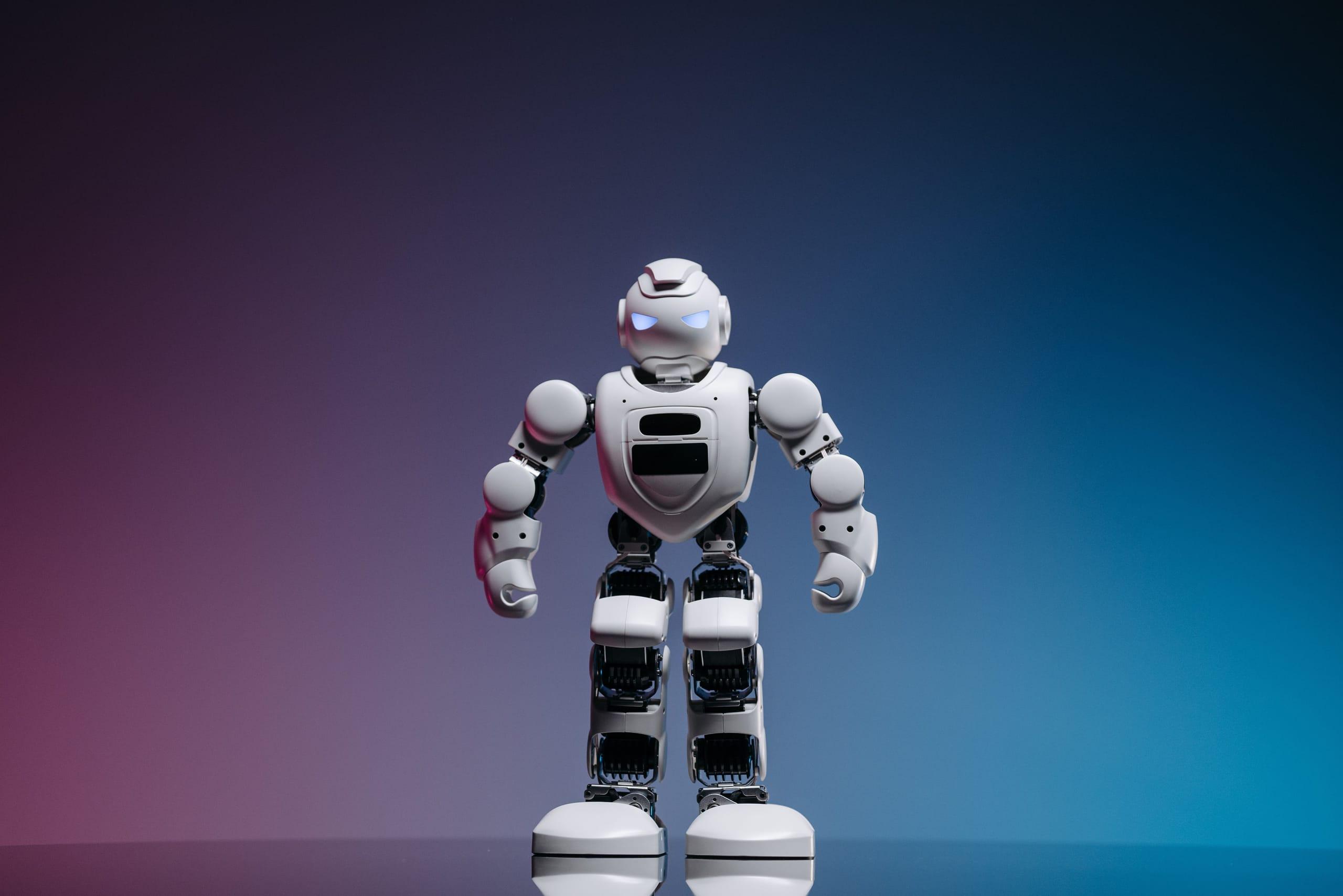 A small toy robot against a pink and blue background